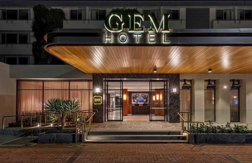 una entrada del hotel con un cartel que diga hotel verde en The Gem Hotel en Griffith