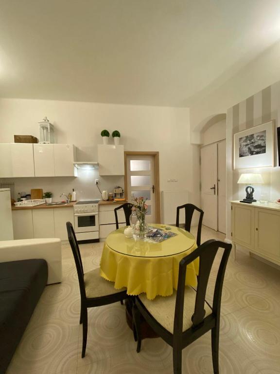 a living room with a table with a yellow table cloth at Apartmány u sv. Michaela in Kadaň