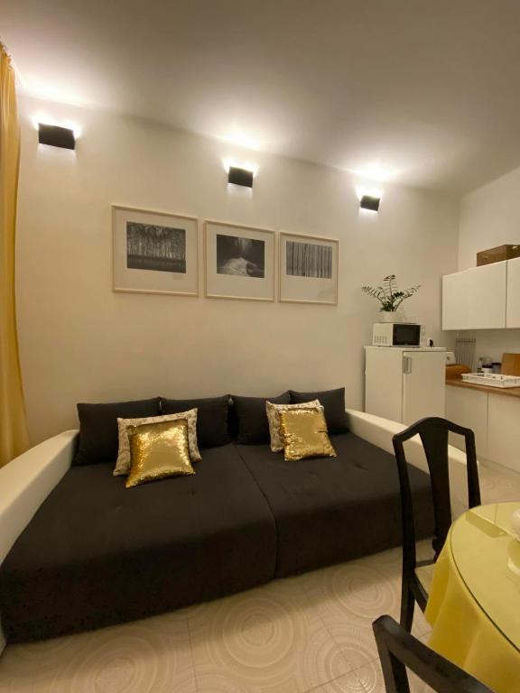 a large black couch in a room with a kitchen at Apartmány u sv. Michaela in Kadaň