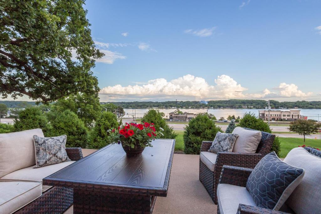 een patio met banken en een tafel met bloemen erop bij River View Lodge in Le Claire