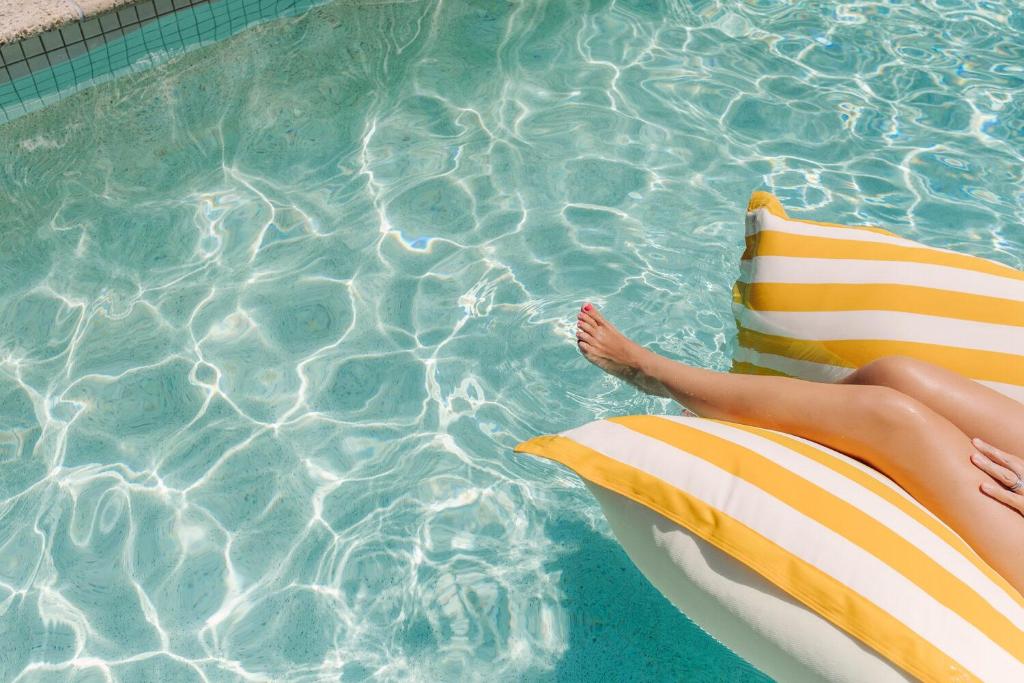 una persona tumbada en una balsa en una piscina en Element on Coolum Beach, en Coolum Beach