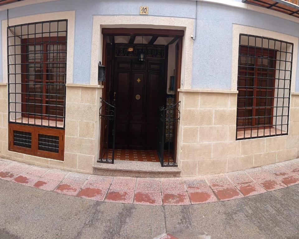a black door on a building with two windows at Casa rural "La Bodega" in Cehegín