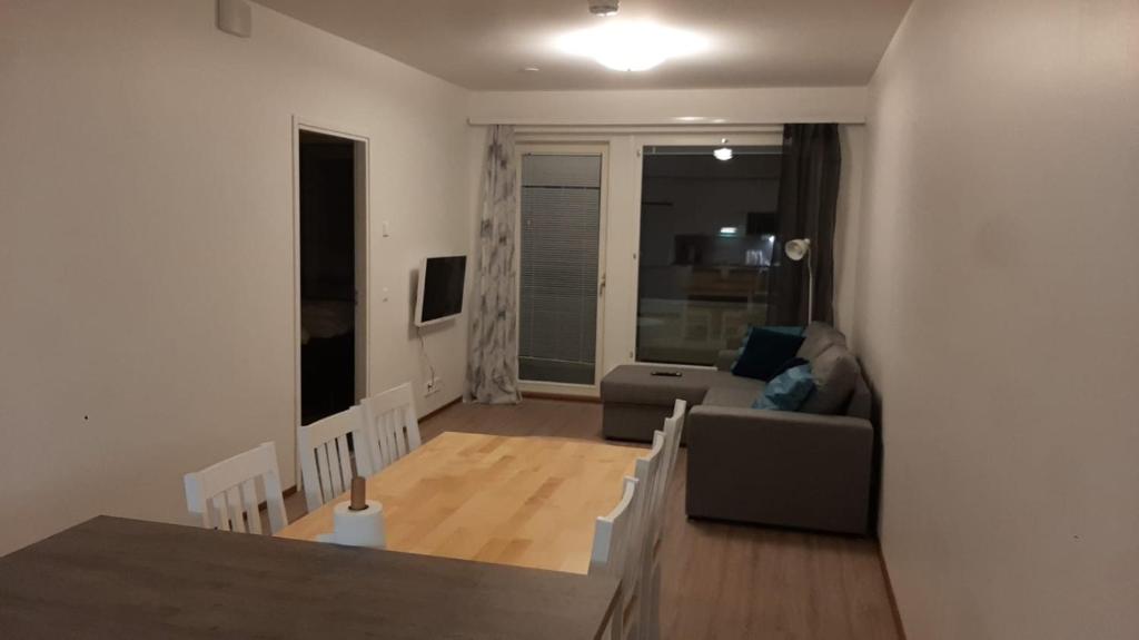 una sala de estar con un sofá y una mesa en Lehtikatu Apartments, en Rovaniemi