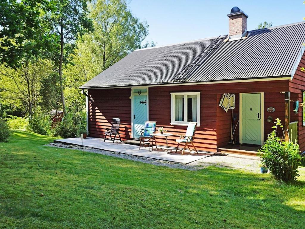 a log cabin with a picnic table and chairs in a yard at 5 person holiday home in HEN N in Henån
