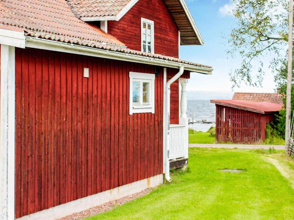 a red house with a red roof and a green yard at Apartment TÄLLBERG in Tällberg