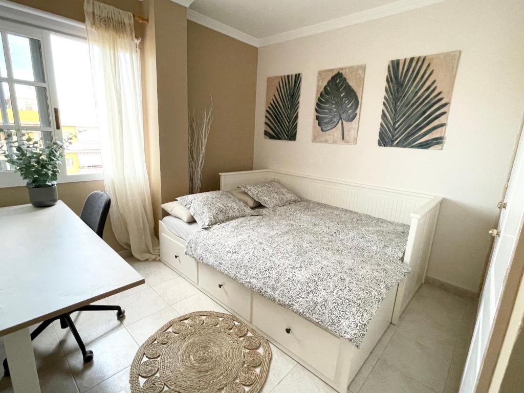 a bedroom with a bed and a desk and a table at Casa del Sol - with Home Office space in Playa de San Juan