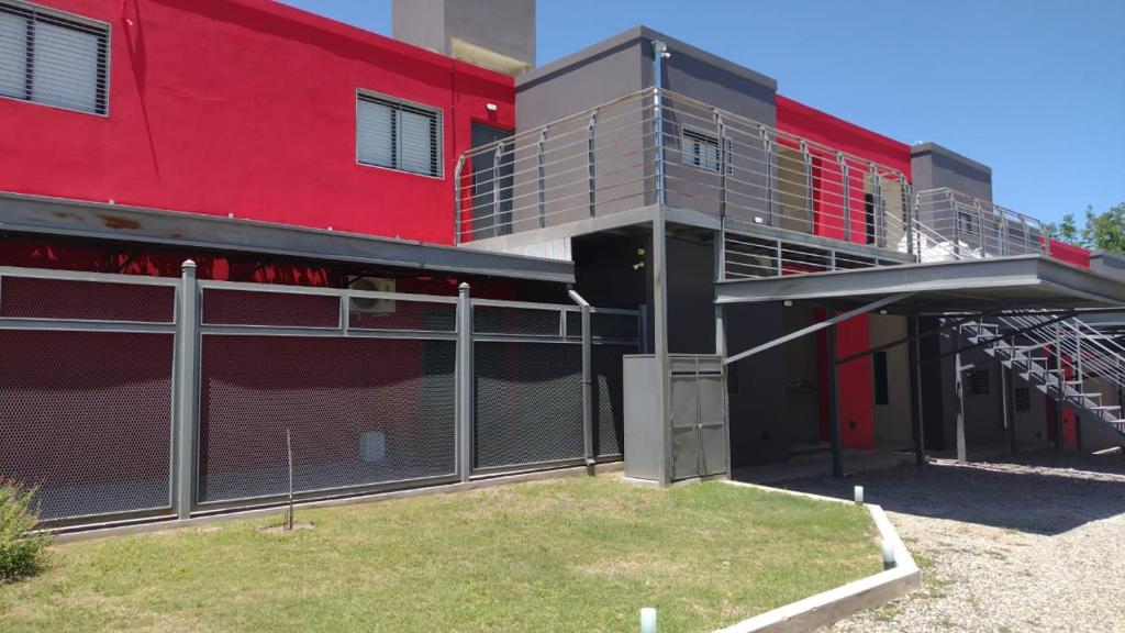 un edificio rojo con balcón y pared roja en Magenta Departamentos en Mina Clavero