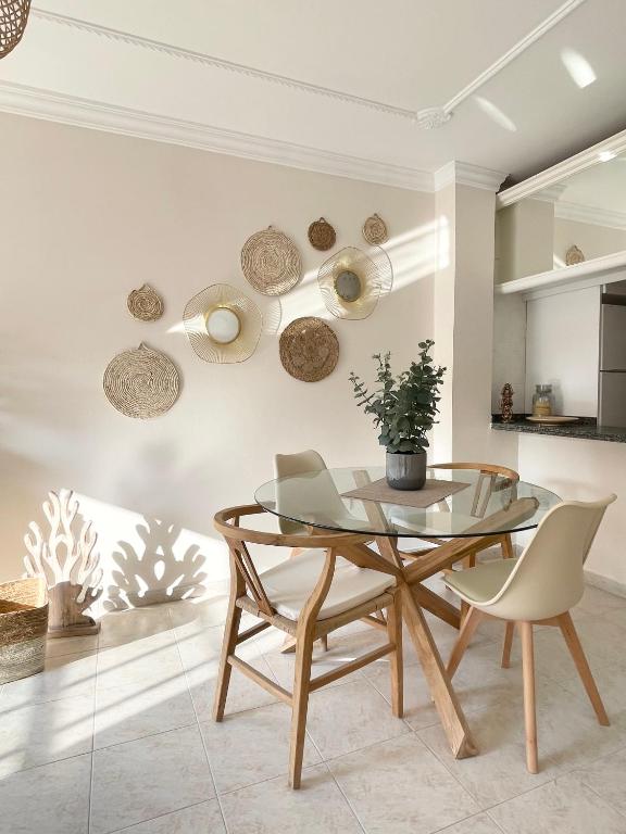 a dining room with a glass table and chairs at Casa del Sol - with Home Office space in Playa de San Juan