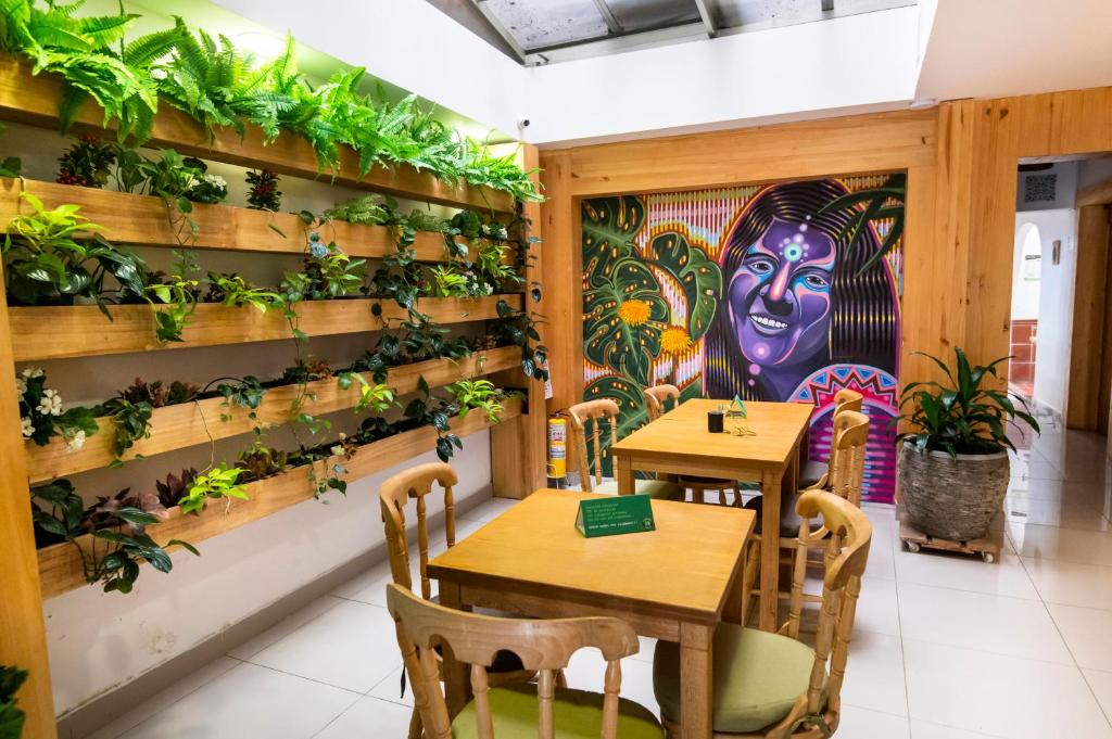 um restaurante com duas mesas e uma parede com plantas em ADN Algo de Nosotros - Malaika em Medellín