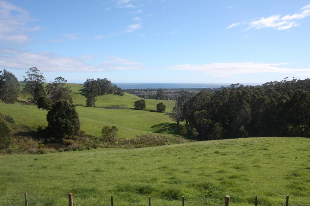 un pasto verde con árboles a lo lejos en Spring Hill, en Forth