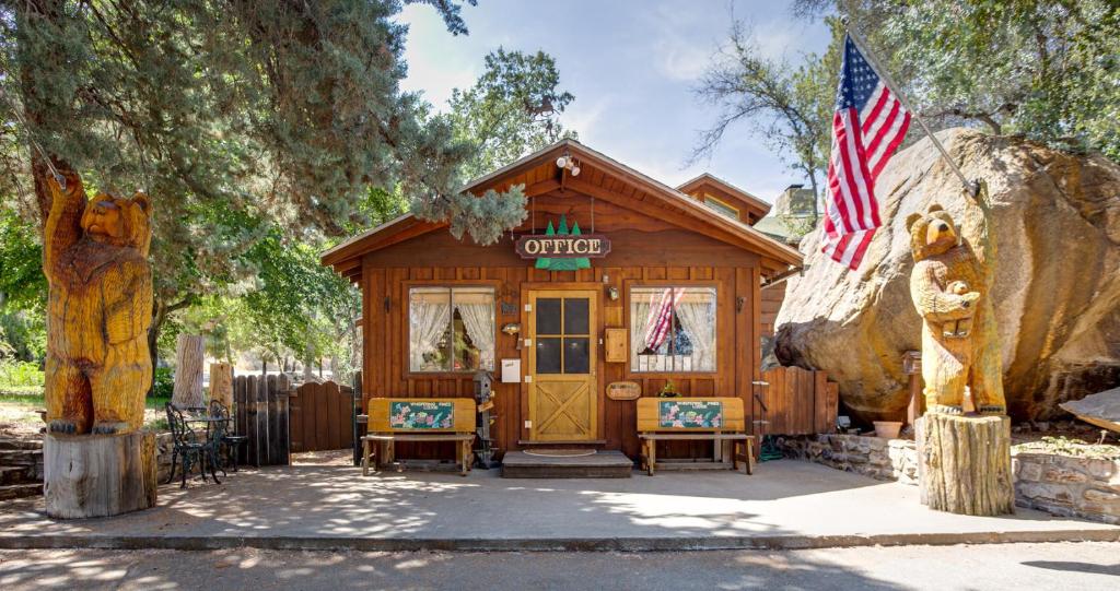 a cabin with an american flag in front of it at Whispering Pines Lodge in Kernville