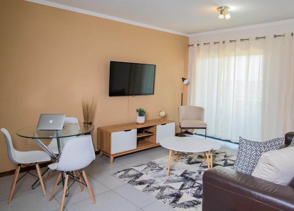 a living room with a couch and a tv at Luxury 2bed 2bath in a Secure golf estate.WIFI in Roodepoort