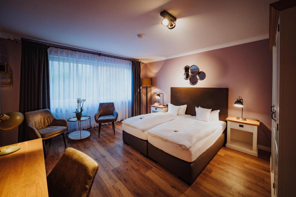 a hotel room with a large bed and a desk at Antik-Hotel EICHENHOF in Bad Salzuflen