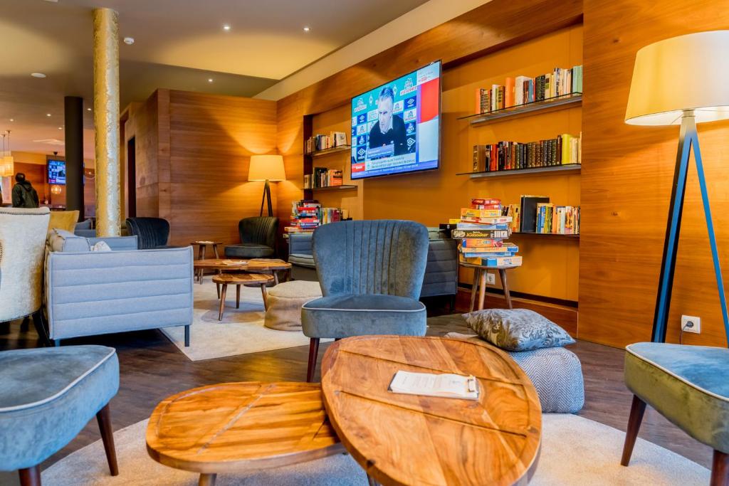 本斯海姆的住宿－巴克斯酒店，客厅配有椅子和电视