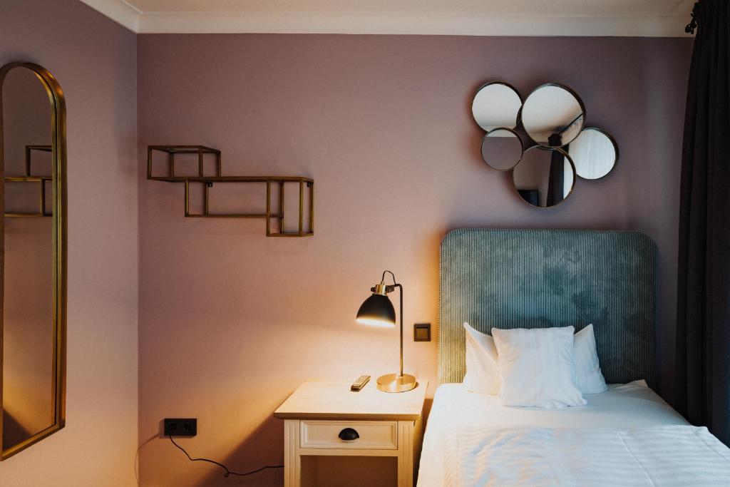 a bedroom with a bed and a lamp and a mirror at Villa Otto in Bad Salzuflen