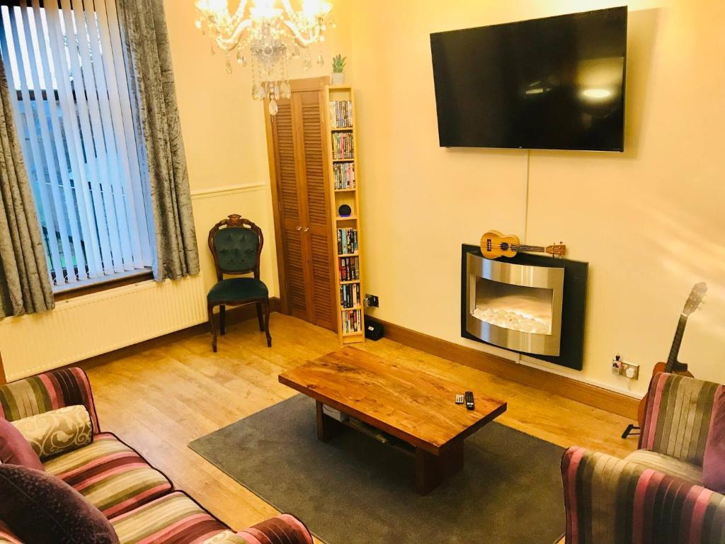 a living room with a coffee table and a tv at Station View Lodge Markinch in Markinch