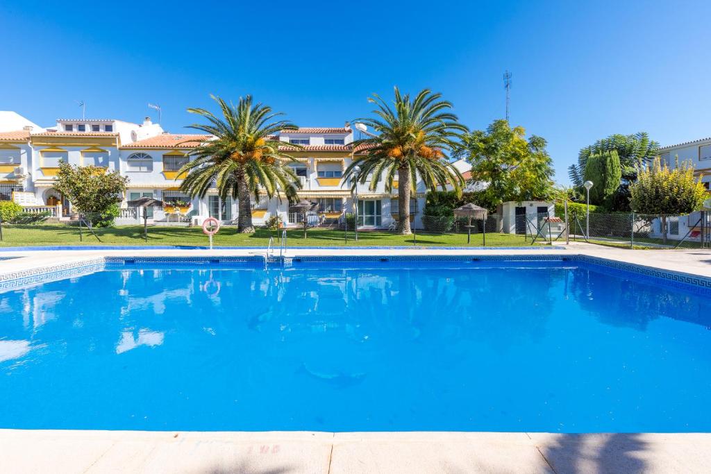 una gran piscina azul frente a un edificio en La Rosa Home, en Torremolinos