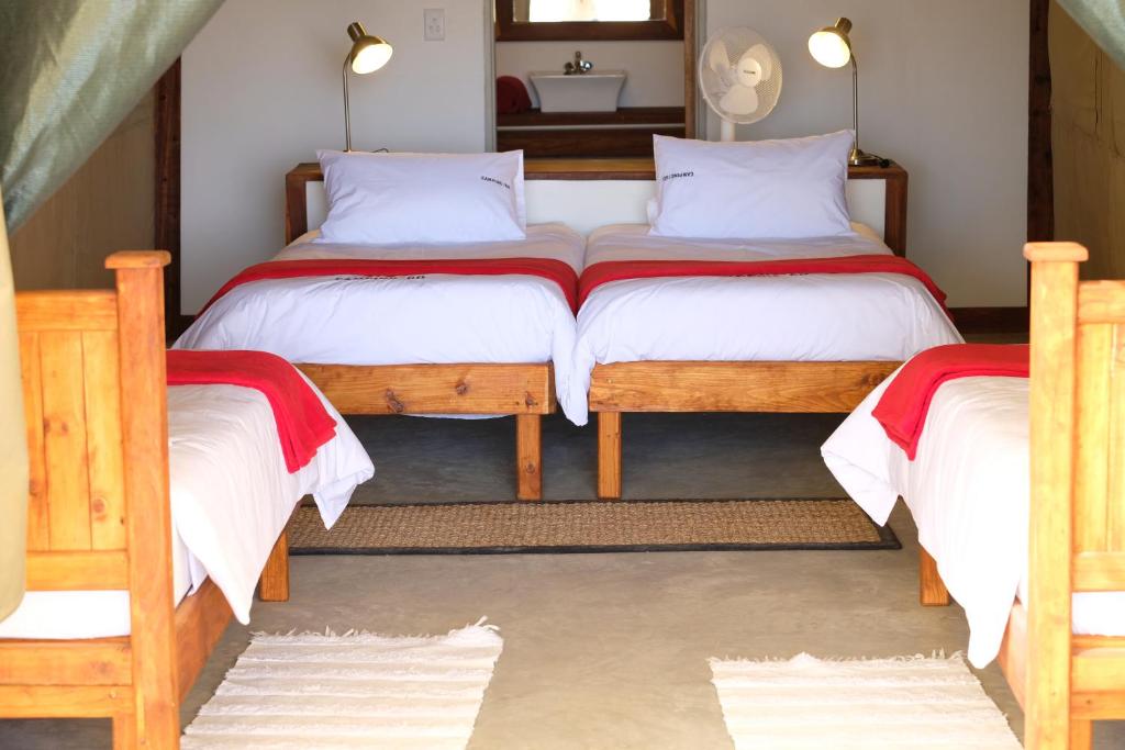 a bedroom with two twin beds and a mirror at Palmwag Camping2Go in Kamanjab