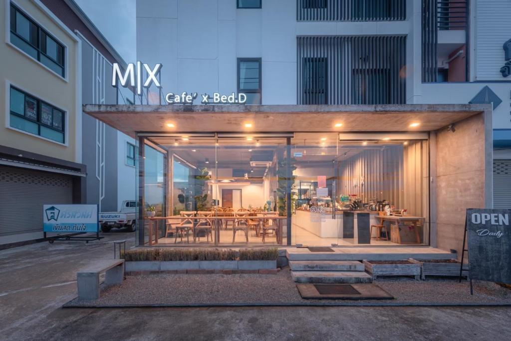 a building with a dining area and a table at Mix cafe x Bed D in Mae Sot