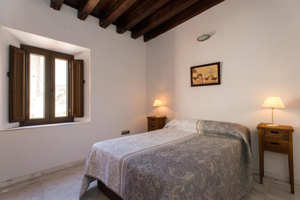 a bedroom with a bed and a window at Bustos Tavera in Seville