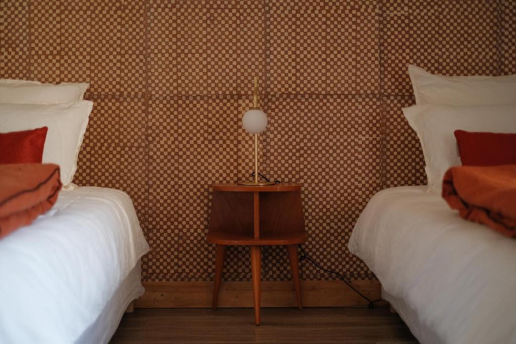 a bedroom with two beds and a table with a lamp at Le Domaine de l&#39;Hostellerie in Le Fresne-Camilly
