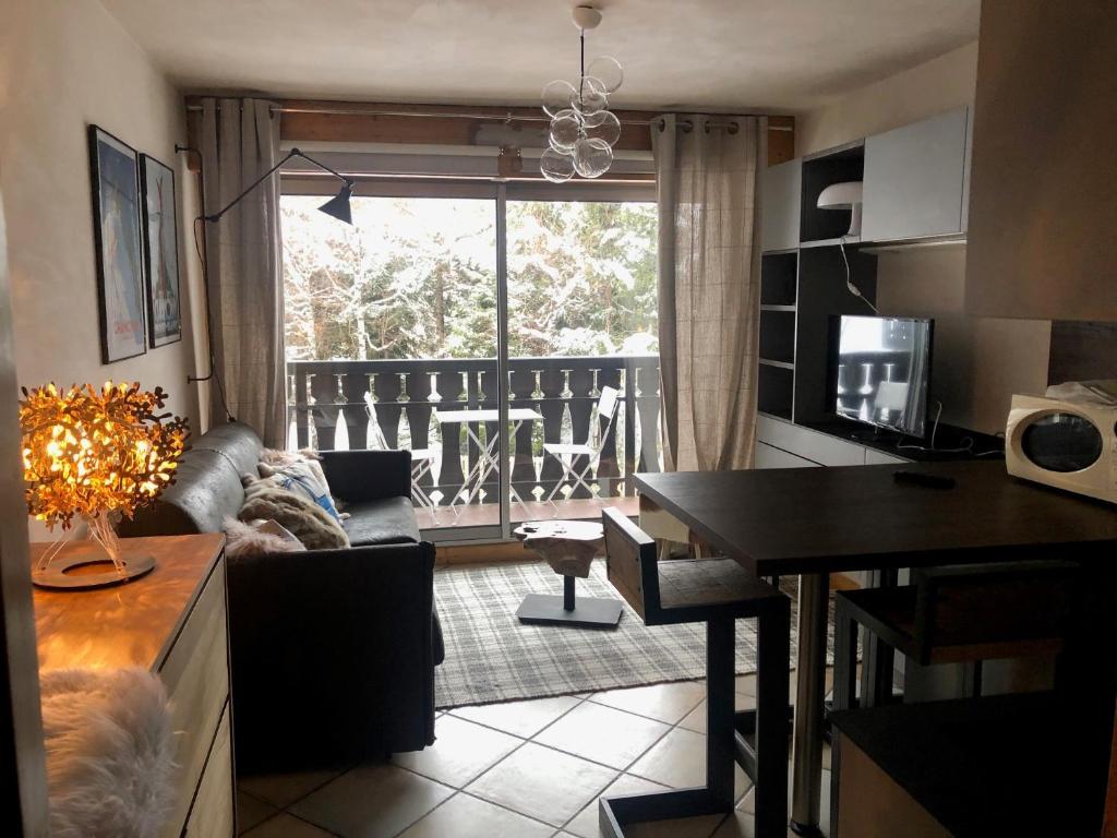 uma cozinha e sala de estar com um sofá e uma mesa em Studio Le 4122 - Chamonix centre Clos du Savoy em Chamonix-Mont-Blanc