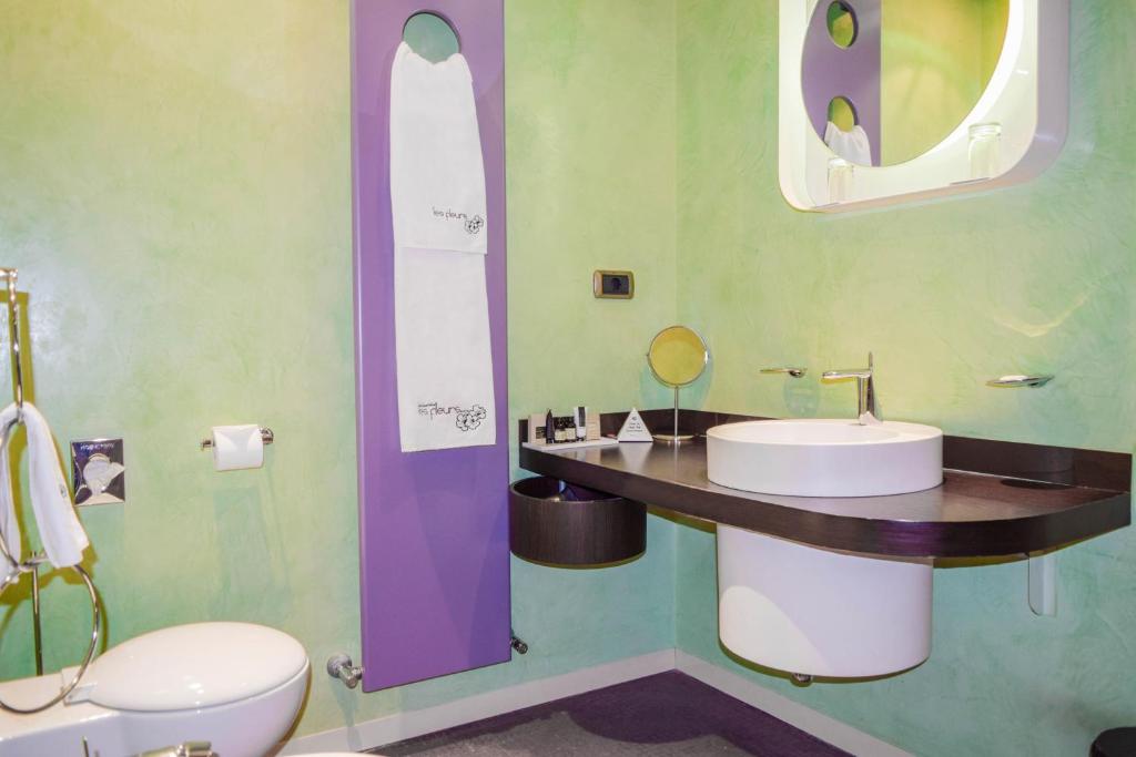 a bathroom with a sink and a toilet and a mirror at Les Fleurs Boutique Hotel in Sofia
