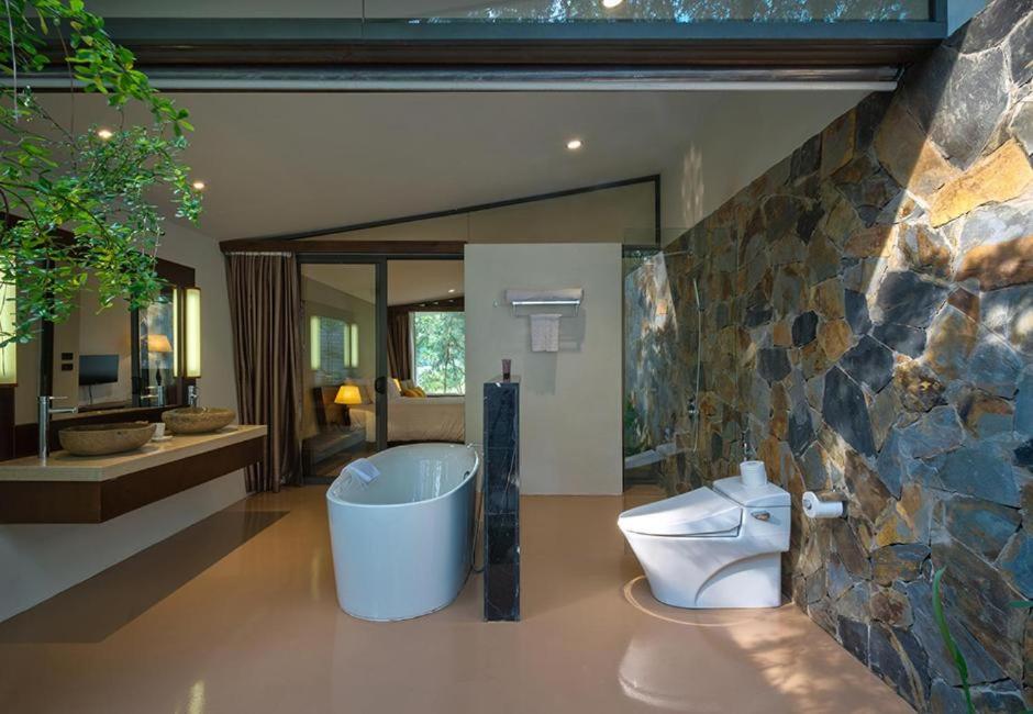 ein Badezimmer mit einer Badewanne, einem WC und einem Waschbecken in der Unterkunft Flamingo Dai Lai Resort - Villa 1 Phòng Ngủ in Xuân Hòa