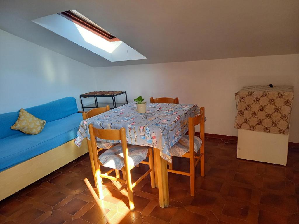 uma sala de jantar com uma mesa e um sofá azul em Piccola mansarda a Porto San Giorgio em Porto San Giorgio