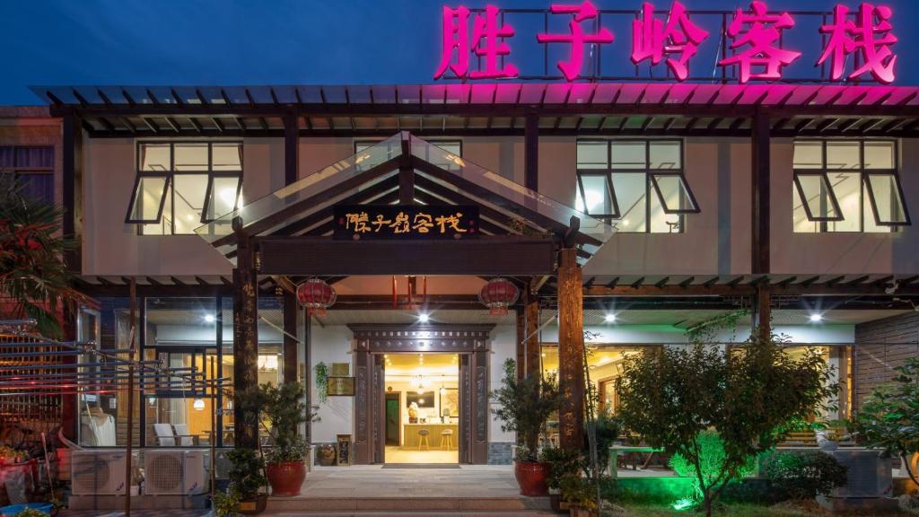 a building with a neon sign in front of it at Floral Hotel Wuxi Shengziling in Wuxi