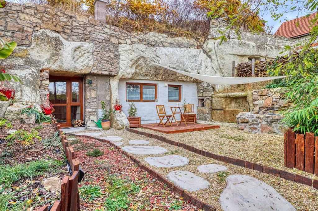 a stone house with a garden and a patio at Barlang Noszvaj in Noszvaj