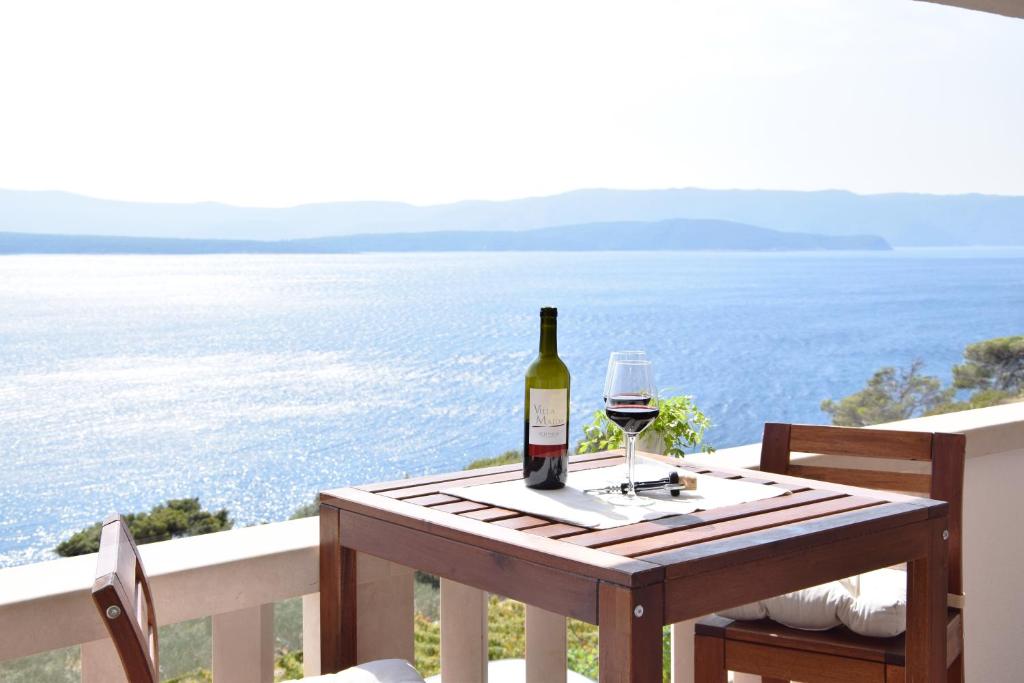 a bottle of wine sitting on a table with a glass at Villa Majda at the Paradise beach in Murvica