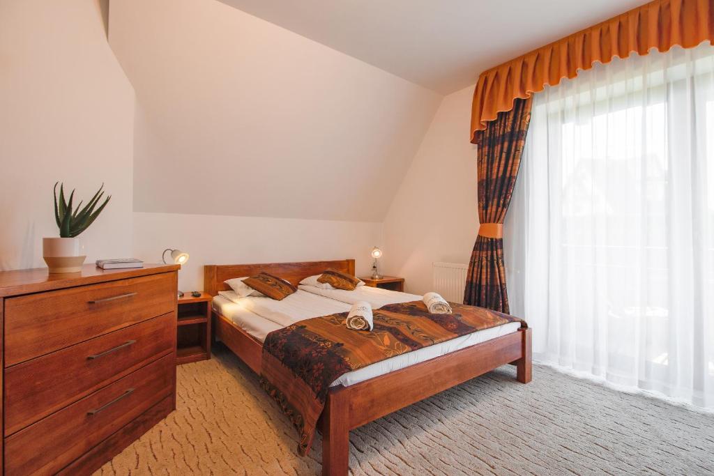 1 dormitorio con 1 cama, vestidor y ventana en WILLA SZMARAGD - Śniadania - Zniżki na Termy - Sauna - Bilard - Stoki Narciarskie, en Bukowina Tatrzańska