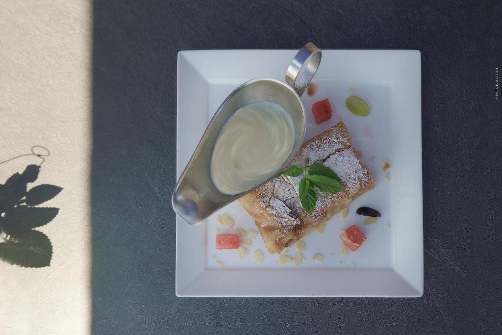 a white plate with a piece of food with a sauce at Hotel Pachernighof in Velden am Wörthersee