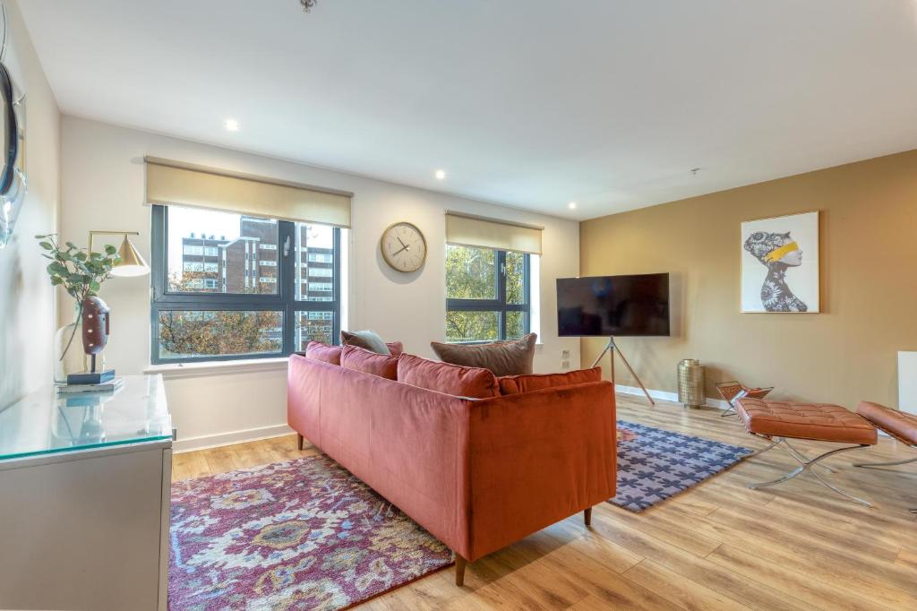 a living room with a couch and a tv at Executive 7 Glasgow City in Glasgow