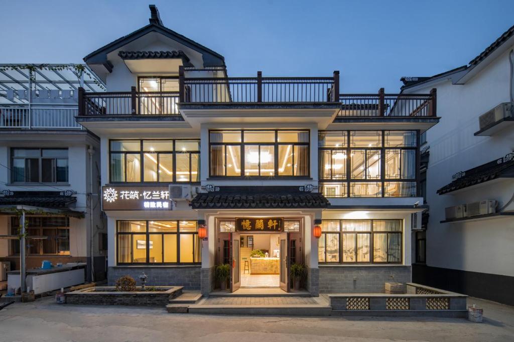 a large white building with a lot of windows at Floral Yilanxuan Zhouzhuang Hotel in Suzhou