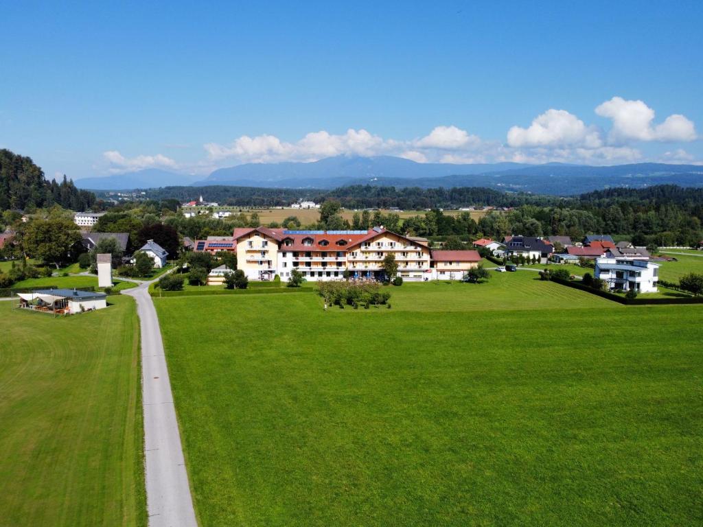 a green field with houses and a road at Hotel Pachernighof in Velden am Wörthersee