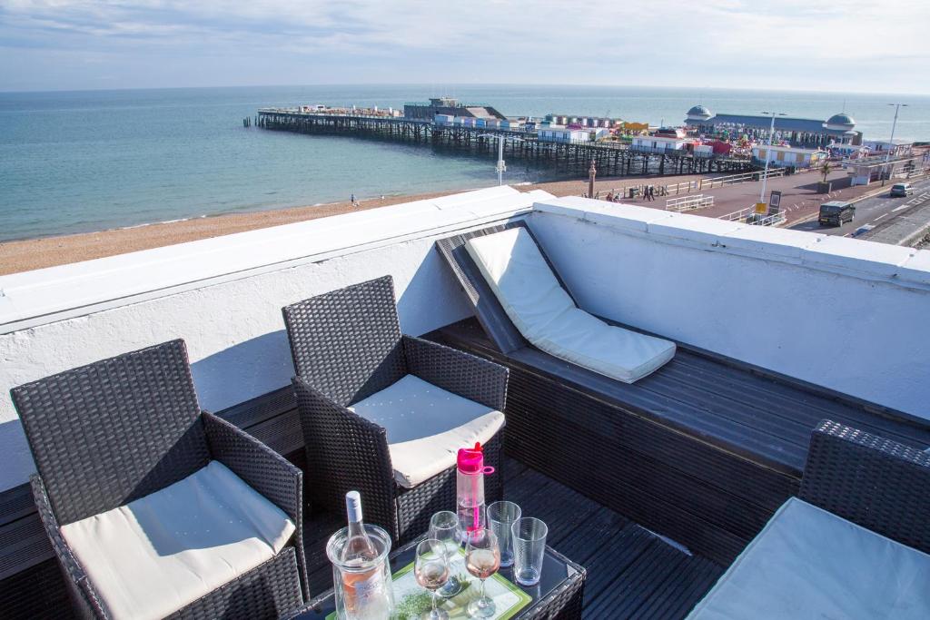 una mesa y sillas en un balcón con vistas al océano en Seagulls Nest Beachfront Apartment With 3 Bedrooms en Hastings