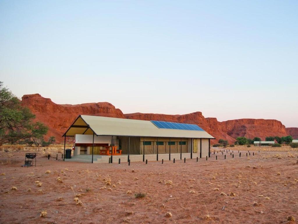 a building in the desert with mountains in the background at Namib Desert Camping2Go in Solitaire