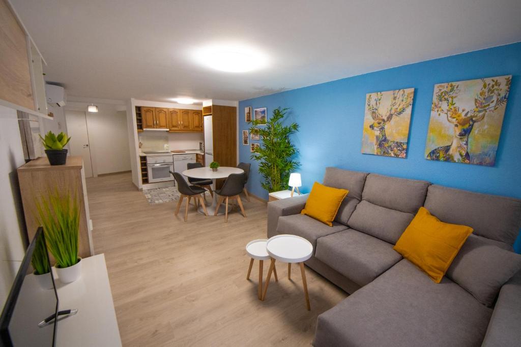 sala de estar con sofá gris y almohadas amarillas en MEQUEDO PLAZA SAN FRANCISCO, en Alcañiz