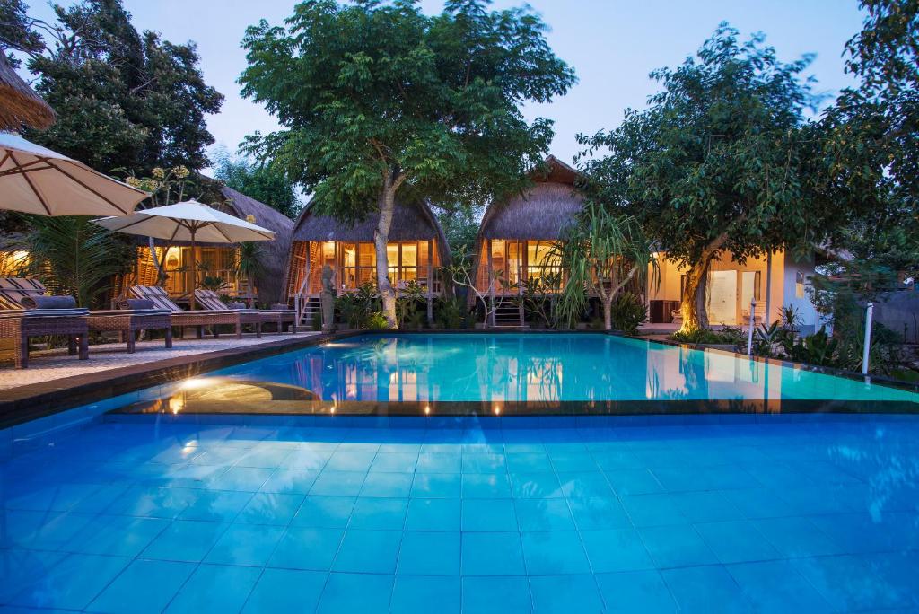 a swimming pool in front of a house at Komodo Garden in Nusa Lembongan