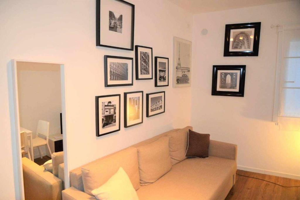 ein Wohnzimmer mit Sofa und Bildern an der Wand in der Unterkunft Nel cuore di Padova SantAgnese apartment in Padua