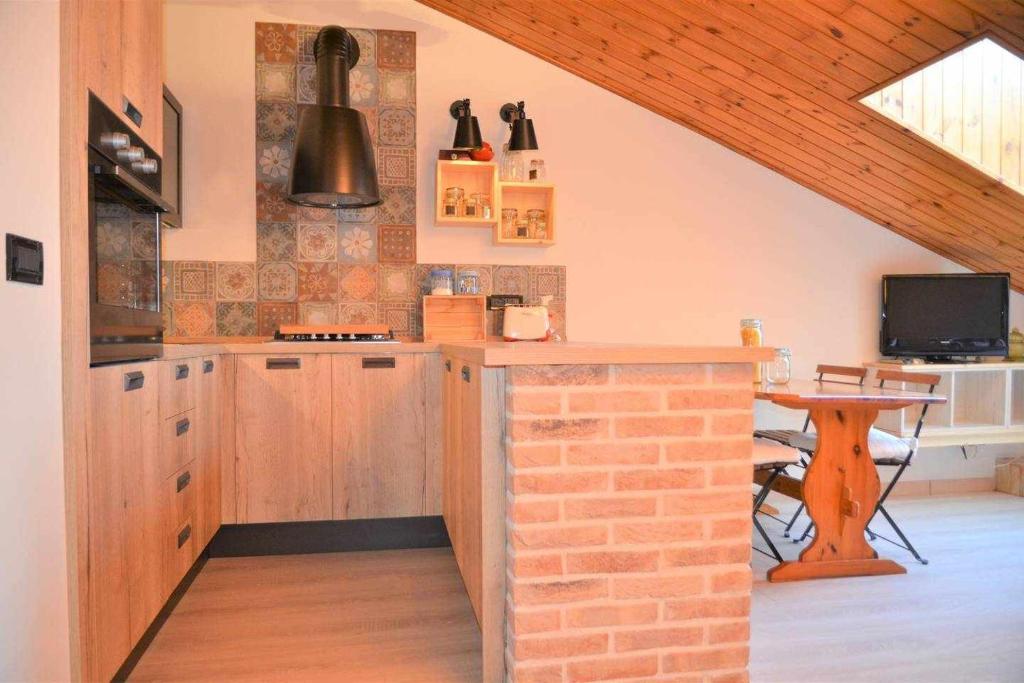 een keuken met houten kasten en een bakstenen muur bij SCroce Apt close to Prato della Valle in Padua