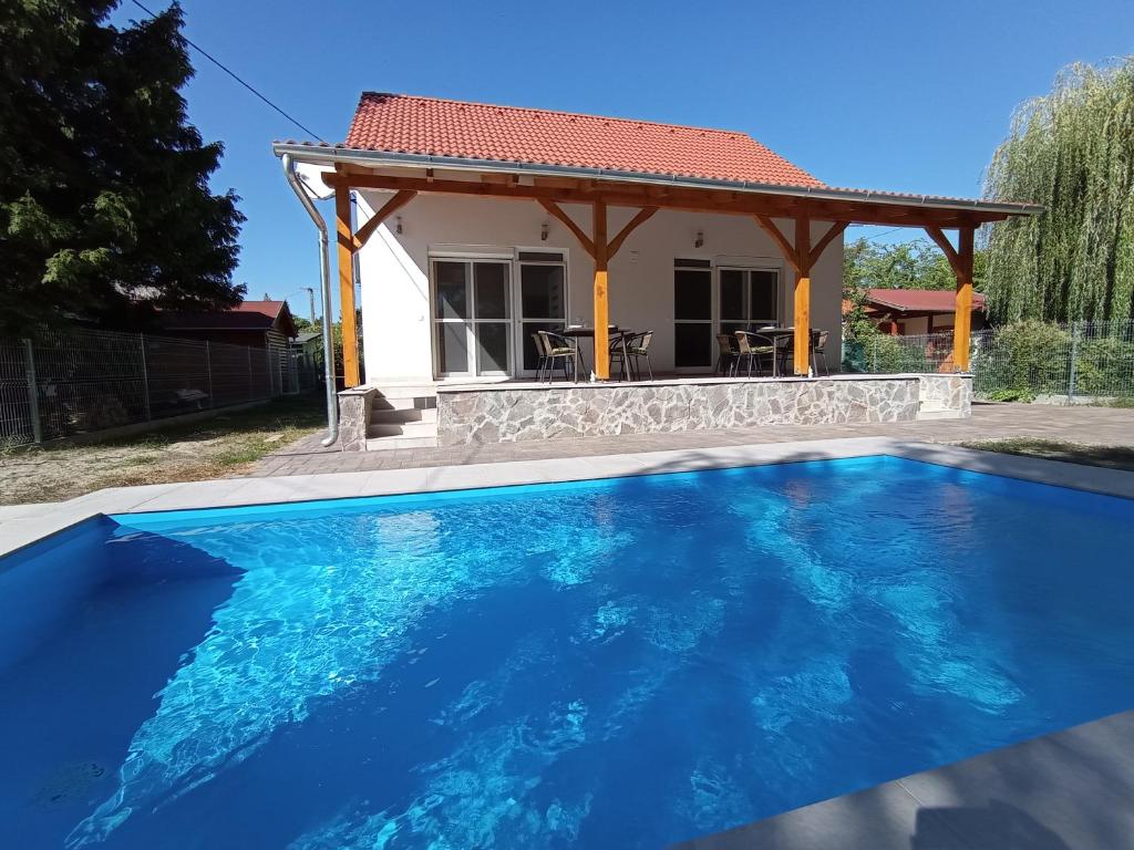 a house with a blue swimming pool in front of a house at Relax Apartment in Fonyód