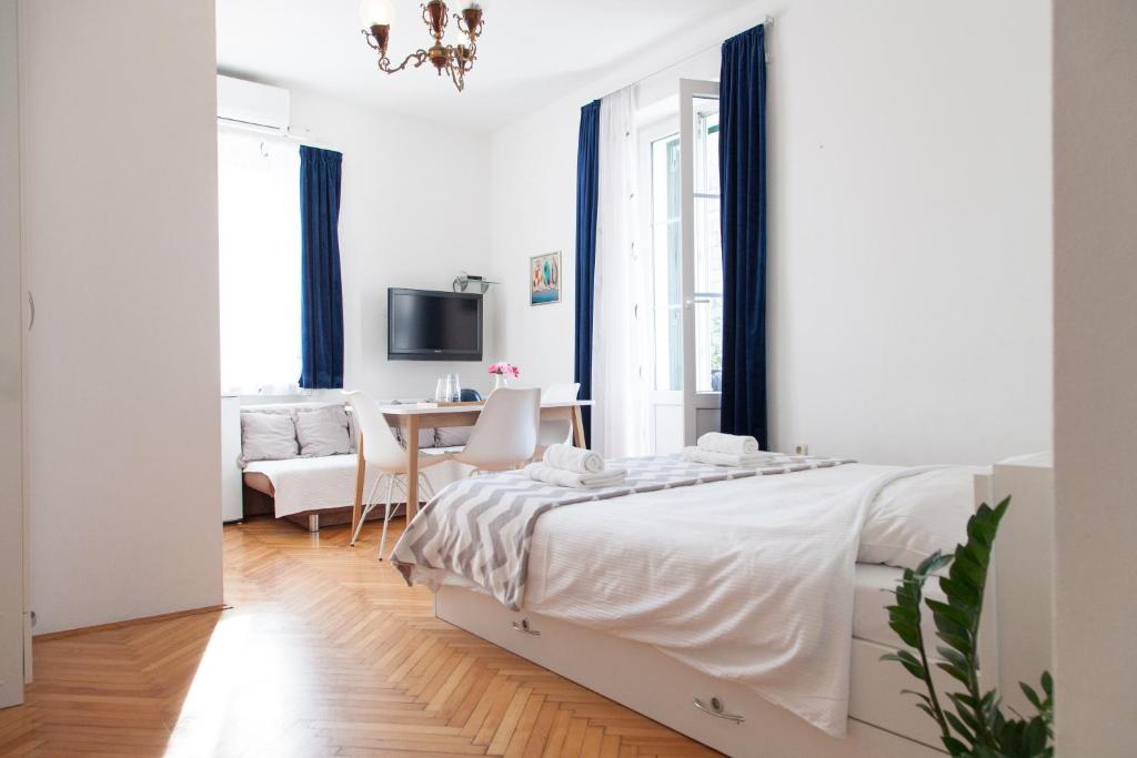 Habitación blanca con cama y escritorio en Milla Rooms en Split