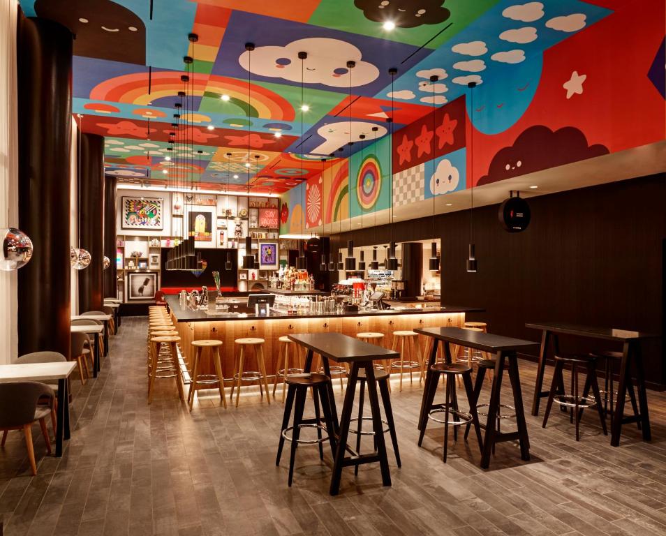 a restaurant with tables and a bar with a colorful ceiling at citizenM San Francisco Union Square in San Francisco