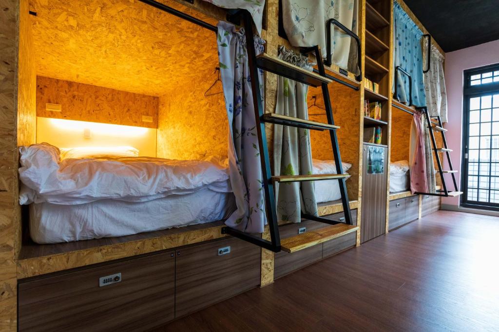 a bedroom with a bed and a bunk room with a ladder at Hostel Alley Inn -桃園民宿075 in Daxi