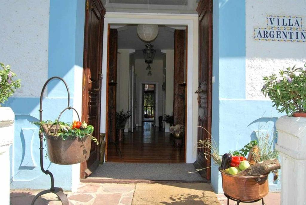 an entrance to a blue building with baskets of fruit at Villa con Jardín para 12 personas in Beinza-Labayen