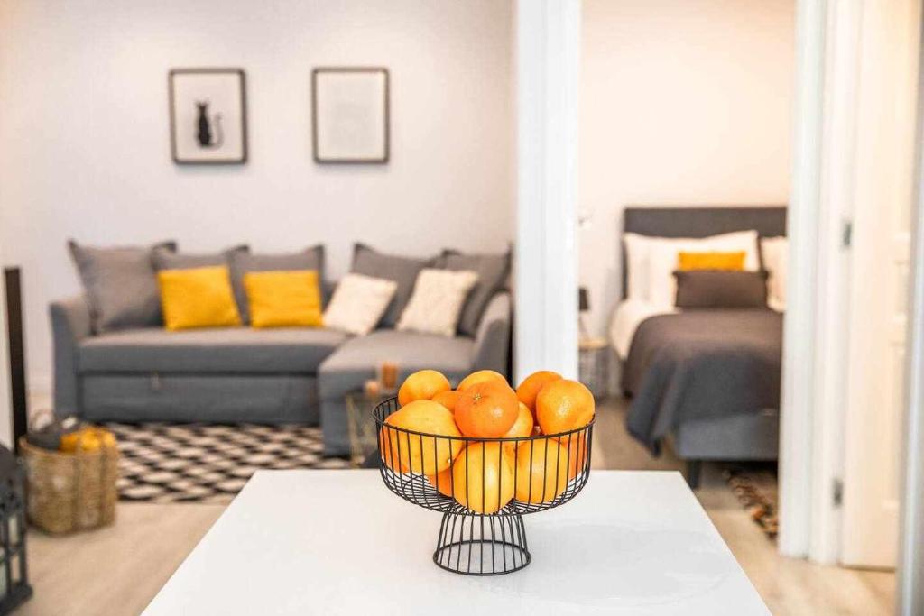 a bowl of oranges on a table in a living room at Casa do Gato Poeta in Leiria