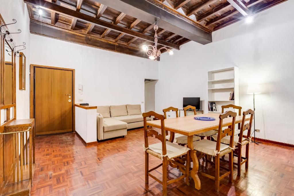 ein Wohnzimmer mit einem Tisch, Stühlen und einem Sofa in der Unterkunft Spanish Steps Spacious Apartment in Rom